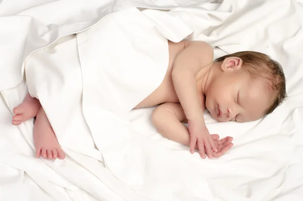 Hermoso inocente recién nacido durmiendo. Adorable niñito relajándose en sábanas blancas después de un baño. Bebé teniendo dulces sueños —  Fotos de Stock