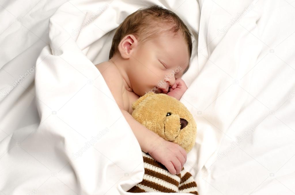 Beautiful innocent newborn sleeping. Adorable little boy relaxing in