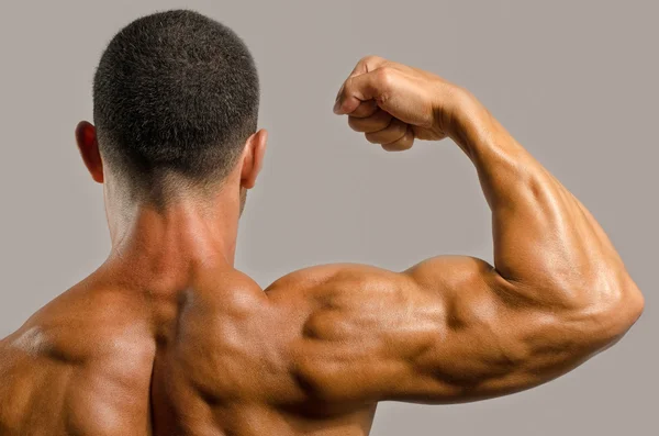 Culturista mostrando i muscoli della schiena, spalle, tricipiti e bicipiti, personal fitness trainer — Foto Stock