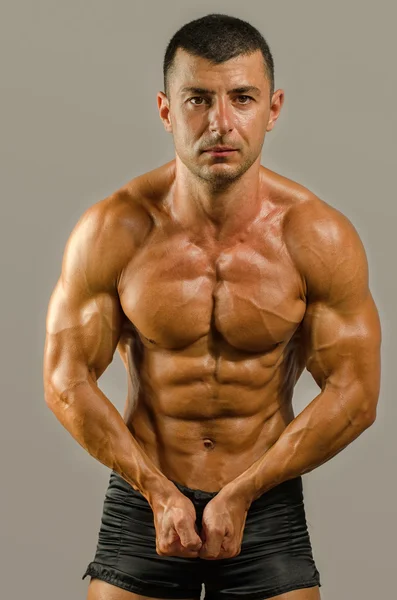 Stark kroppsbyggare med sex-pack. Stark bodybuilder man med perfekta abs, axlar, biceps, triceps och bröst, personlig tränare muskelbygge hans muskler — Stockfoto