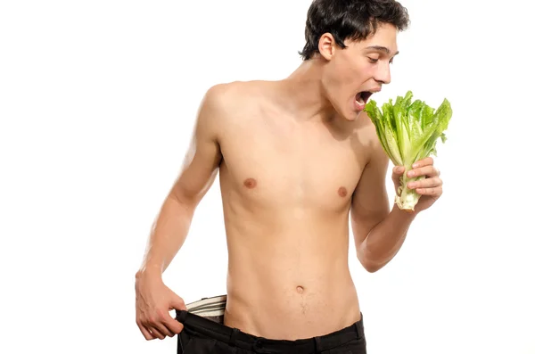 Ein hagerer junger Mann isst einen gesunden Bio-Salat und ernährt sich. Grünes Essen für ein gesundes Leben und eine perfekte Ernährung — Stockfoto