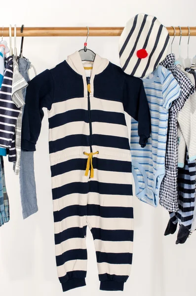 Armoire de dressing avec des vêtements disposés sur cintres. Armoire marine de nouveau-né, enfants, tout-petits, bébés sur un rack. Beaucoup de t-shirts, pantalons, chemises, chemisiers, une seule pendaison — Photo