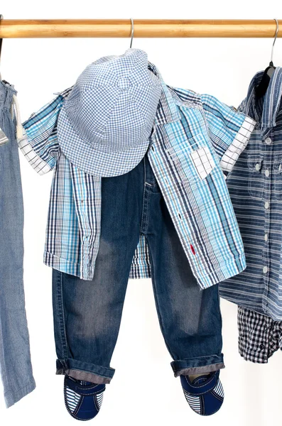 Dressing closet with clothes arranged on hangers.Blue and white wardrobe of newborn,kids, toddlers, babies full of all clothes.T-shirts,pants, shirts,blue hat hanging — Stockfoto