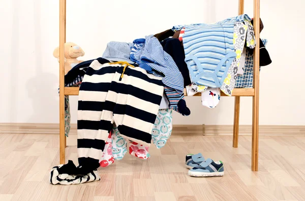 Armadio di neonati, bambini, bambini, bambini.Molte t-shirt, pantaloni, camicie, scarpe, cappello, camicette, tute in un mucchio. Vestiti disordinati gettati su uno scaffale — Foto Stock