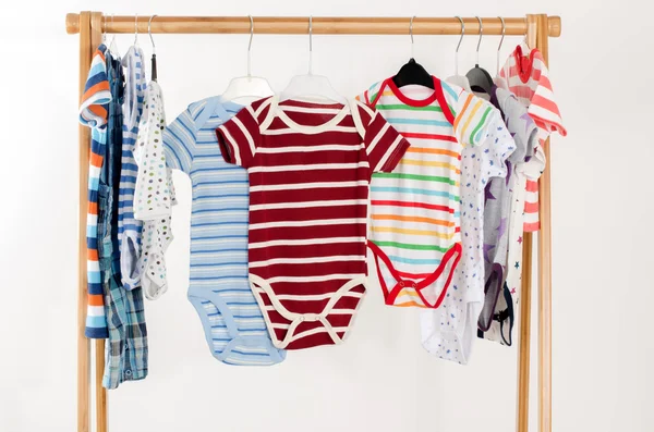 Armário de vestir com roupas organizadas em hangers.Colorful onesie de recém-nascido, crianças, crianças, bebês em uma raça.Muitos t-shirts coloridas, camisas, blusas, onesie pendurado — Fotografia de Stock