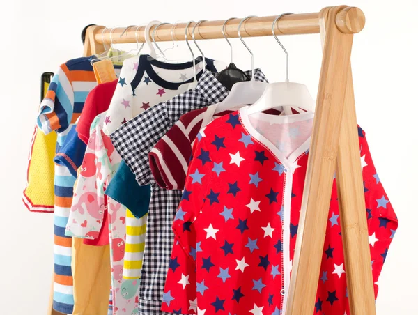 Dressing closet with clothes arranged on hangers.Colorful wardrobe of newborn,kids, toddlers, babies full of all clothes.Many t-shirts,pants, shirts,blouses, onesie hanging — Stock Photo, Image