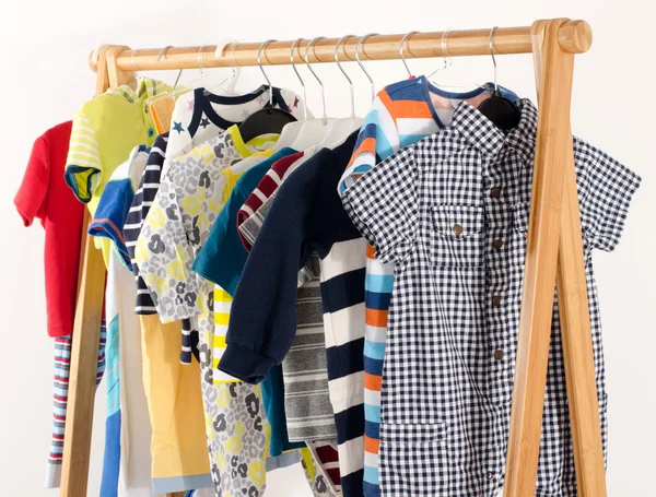 Armoire de dressing avec des vêtements disposés sur cintres. Armoire colorée de nouveau-né, enfants, tout-petits, bébés pleins de tous les vêtements. De nombreux t-shirts, pantalons, chemises, chemisiers, une pendaison — Photo