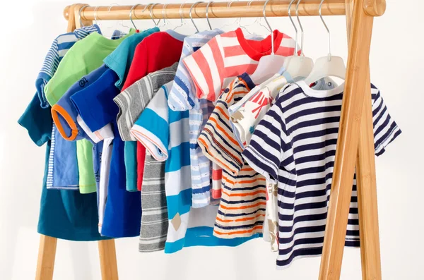 Kleiderschrank mit Kleidung auf Kleiderbügeln arrangiert.Bunte Garderobe von Neugeborenen, Kindern, Kleinkindern, Babys voller Kleidung. Viele T-Shirts, Hosen, Hemden, Blusen, Onesie hängen — Stockfoto