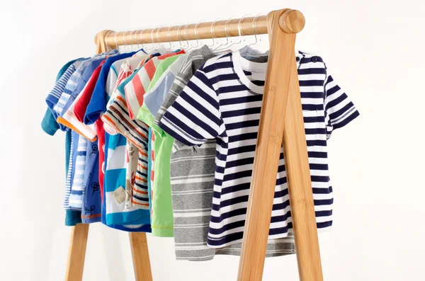 Kleiderschrank mit Kleidung auf Kleiderbügeln arrangiert.Bunte Garderobe von Neugeborenen, Kindern, Kleinkindern, Babys voller Kleidung. Viele T-Shirts, Hosen, Hemden, Blusen, Onesie hängen — Stockfoto