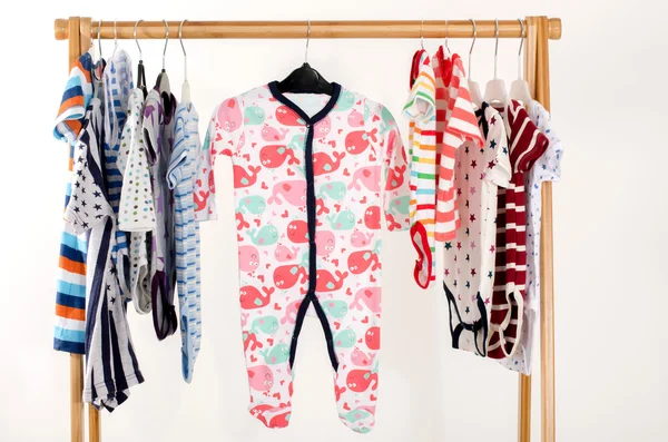 Dressing closet with clothes arranged on hangers.Colorful onesie of newborn,kids, toddlers, babies on a rack.Many colorful t-shirts, shirts,blouses, onesie hanging Stock Kép