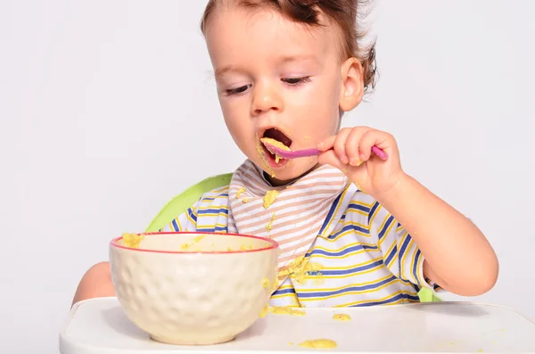 Baby eating food with a spoon, toddler eating messy and getting — Stock Photo, Image