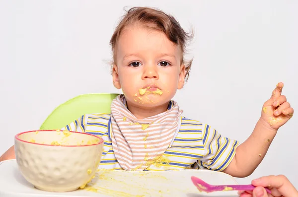 Bambino mangiare cibo con un cucchiaio, bambino mangiare disordinato e ottenere — Foto Stock
