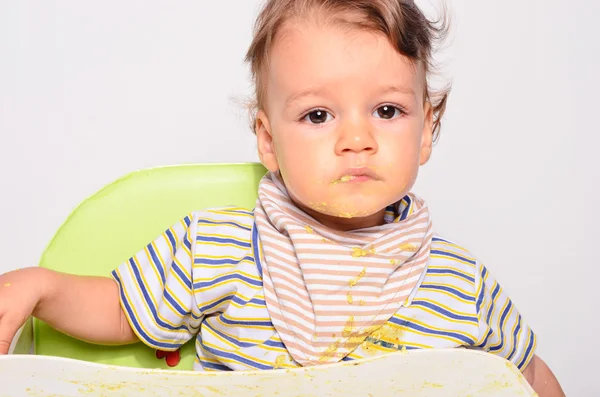 Baby eating food with a spoon, toddler eating messy and getting — Zdjęcie stockowe