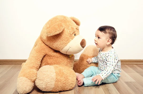 Beautiful innocent newborn speaking with his best friend, teddy