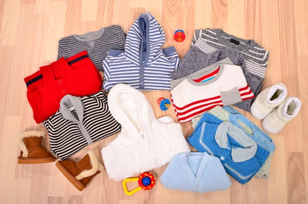 Babykleidung auf dem Boden liegend. Winter-Kinderpullover arrangiert. — Stockfoto