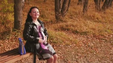 Sokakta hamile bir kadın bankta karnını okşuyor..