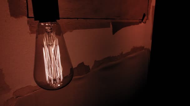 Une lampe à incandescence en tungstène illumine une pièce sombre. — Video