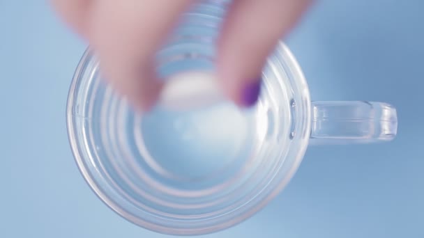 Effervescent tablet dissolves in a glass of water bubbles. — Stock Video