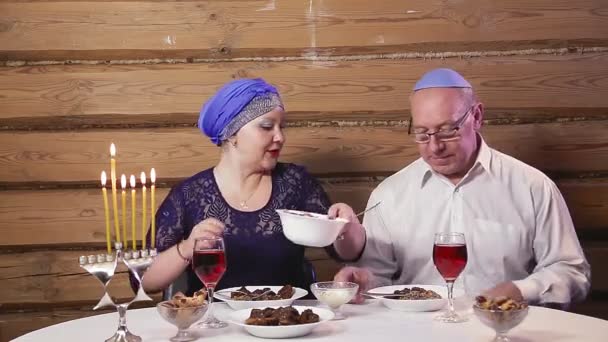 유대인들은 머리쓰개를 쓰고 아내와 결혼 했습니다 하누카 와인을 마시던 시절에 테이블에서 키파를 하던 한 남자가. — 비디오