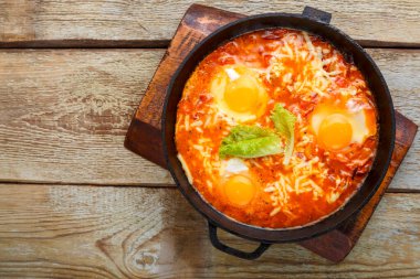 İsrail usulü omlet, ahşap bir masada kızartma tavasında. Boşluğu kopyala