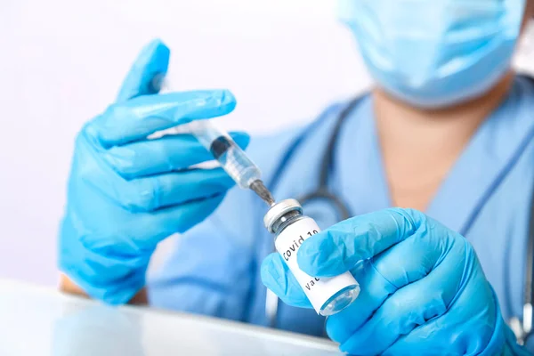 Een handschoenarts vult een spuit met een vaccin om het virus te voorkomen. — Stockfoto