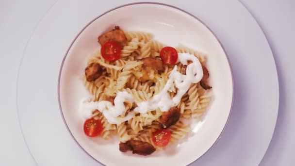 意大利面，鸡肉和奶酪，西红柿在灰色盘子里旋转成圆形 — 图库视频影像