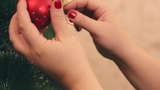 As mãos das mulheres decoram uma árvore de Natal com bolas — Vídeo de Stock