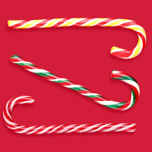 Bastoncini di caramelle lecca-lecca Natale su sfondo rosso — Foto Stock