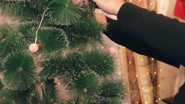 As mãos de um homem decorar uma árvore de Natal com lâmpadas elétricas — Vídeo de Stock