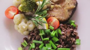 Mercimek, domates ve biberiyeli fırında balık daire şeklinde döner. Yakın plan.