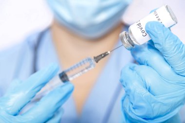 Eldivenli bir doktor şırıngayı virüs aşısıyla dolduruyor. Yatay fotoğraf