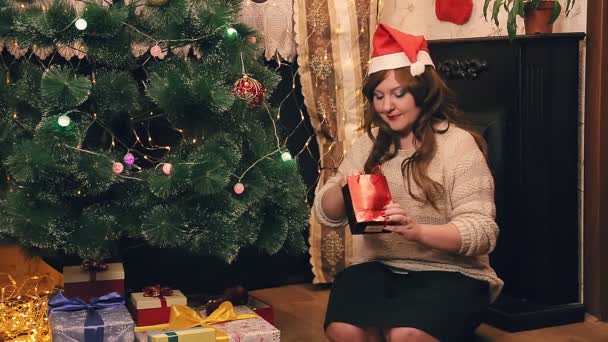 圣诞节时 一位妇女在圣诞树前检查礼物 总体计划 — 图库视频影像