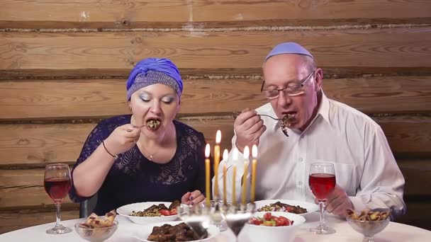 의상을 유대인 부부가 하누카에서 촛불을 잔치상에서 와인을 마시고 전반적 — 비디오