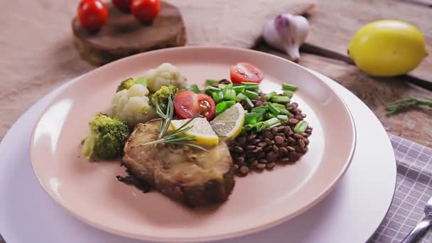 Kurutulmuş balık, mercimek, brokoli ve biberiye bej bir tabakta, tezgahta daire şeklinde döner.. — Stok video