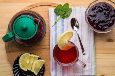 Limon, bal, limon, merhem, zencefil ve yuvarlak ahşap tezgahın üzerinde bir çaydanlık..