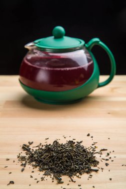 Limonlu bir çaydanlık ve masaya saçılmış çay yaprakları..