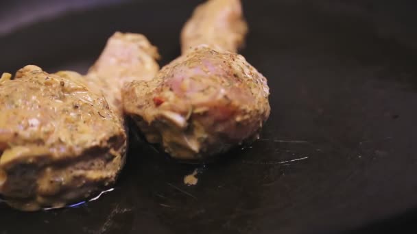 A womans hand lays the crooked legs and wings in a pan with butter — Stock Video