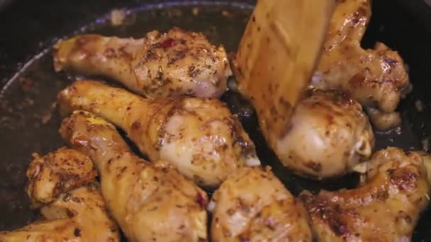 Η ξύλινη σπάτουλα γυρίζει το μπούτι κοτόπουλο πάνω σε ένα τηγάνι με βούτυρο — Αρχείο Βίντεο