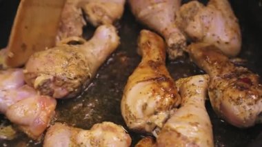 Tahta bir spatula tavuğu tereyağı tavasına çevirir.