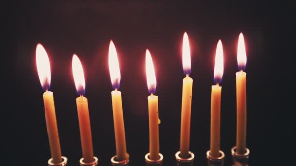 Menora mit brennenden Kerzen auf schwarzem Hintergrund im Dunkeln dreht sich im Kreis — Stockvideo