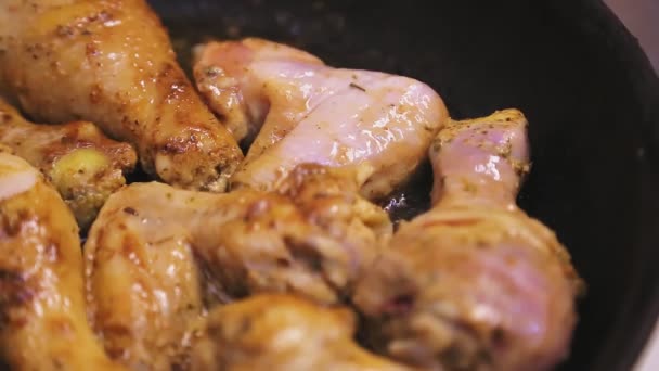 A wooden spatula turns chicken pieces in a butter pan — Stock Video