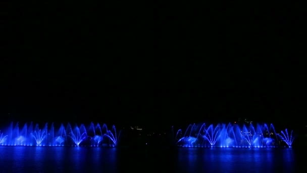 Leuchtende Fontänen in verschiedenen Farben bei einer nächtlichen Wassershow. — Stockvideo