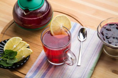 Limon, bal, limon, merhem, zencefil ve yuvarlak ahşap tezgahın üzerinde bir çaydanlık..