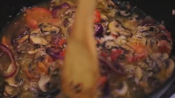 У сковороді з грибами та цибулею помідори та рис змішують зі шпателем . — стокове відео