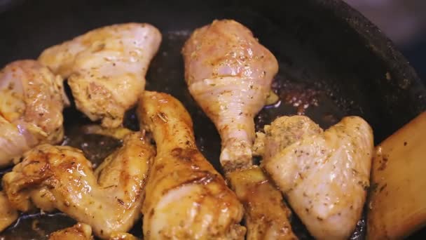 La spatola di legno gira la coscia di pollo in una padella con il burro — Video Stock