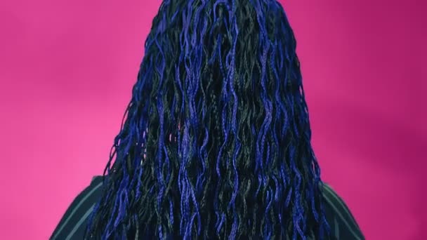 Bakifrån av en judisk kvinna med blå afro flätor vänder ansiktet och fioler med handen — Stockvideo