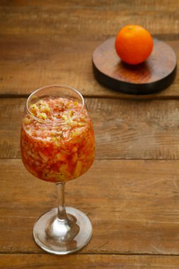 Mandalina tezgahının yanındaki ahşap masada bir bardak taze kivi elmalı smoothie. Dikey fotoğraf