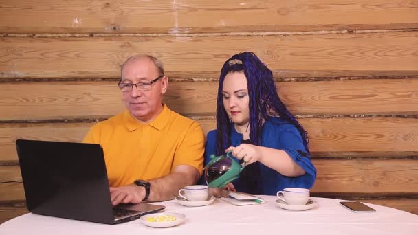 Małżeństwo Przy Stole Pracujące Przy Komputerze Pijące Herbatę Plan Ogólny — Wideo stockowe