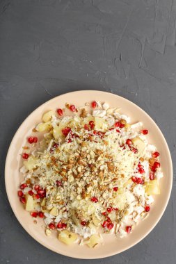 Tavuklu salata, ananas, nar ve fındıklı beton zemin. Dikey fotoğraf