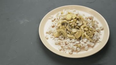 Doğranmış ananas, doğranmış tavuk filetosu ve şampiyonlarla dolu bir tabağa dökülür. Ortam planı
